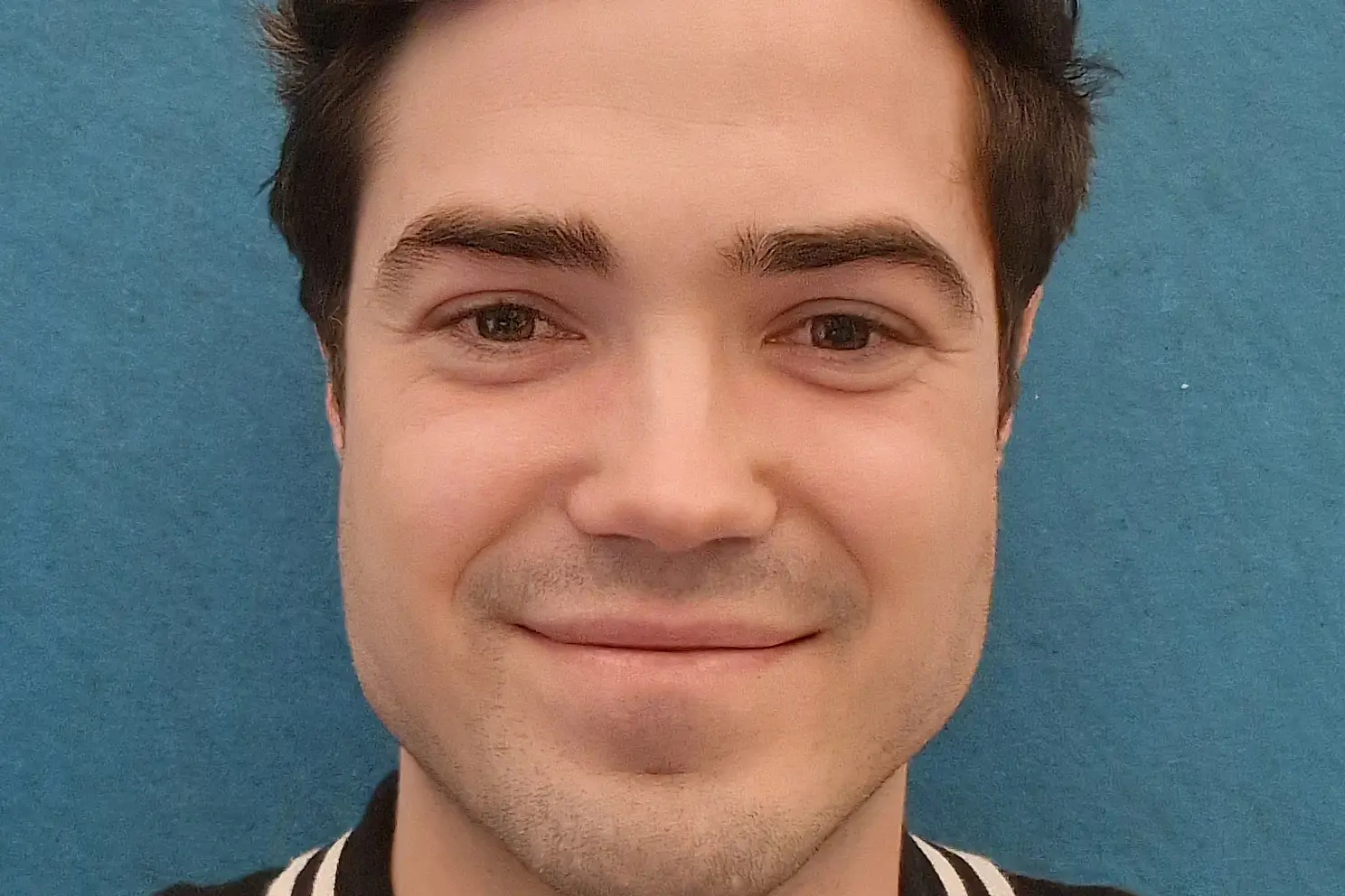 En mann som smiler til kameraet