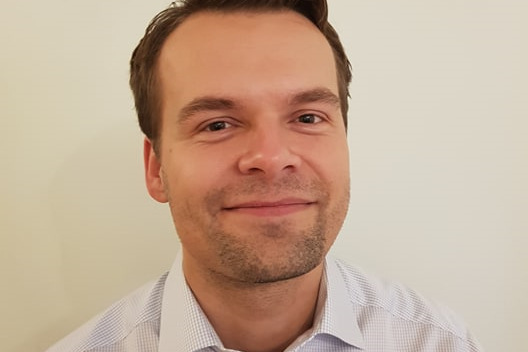 En mann som smiler til kameraet