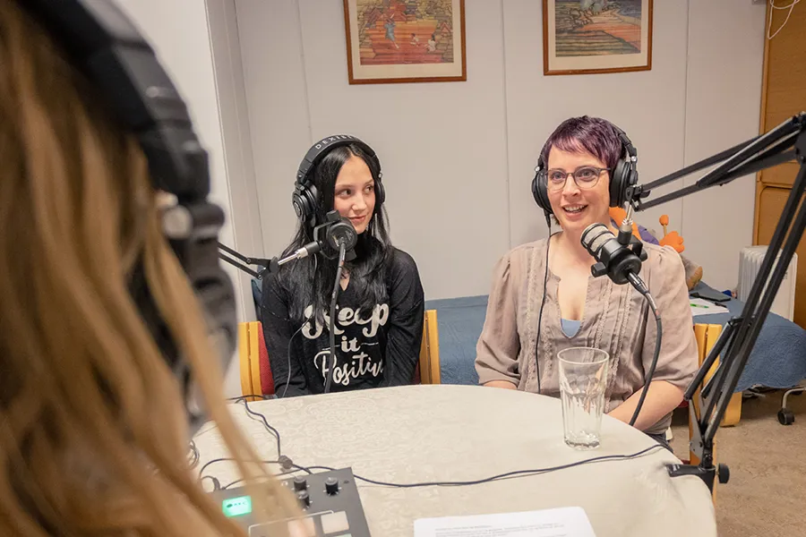 A group of women sitting at a table with microphones