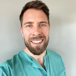 En mann som smiler til kameraet