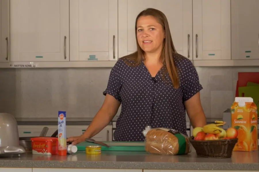 Sykepleier bak kjøkkenbenk med matvarer på