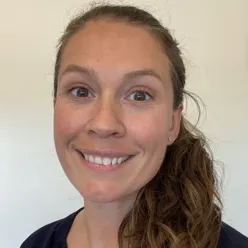 En kvinne som smiler til kameraet