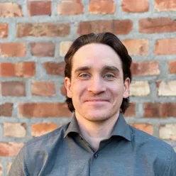 En mann som smiler til kameraet