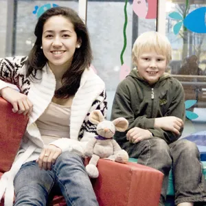 Tøymusen Rasmus sitter sammen med en gutt og en jente