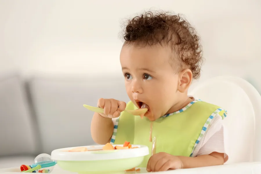 En baby som spiser fra en bolle