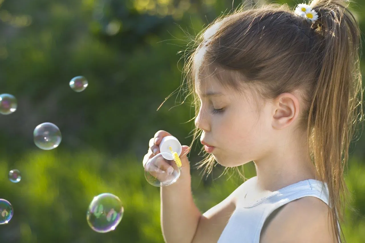 En jente som blåser bobler