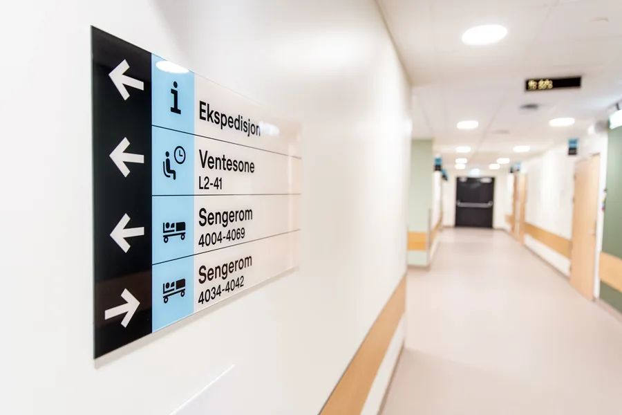 Sykehusgang med skilt til avdelingene