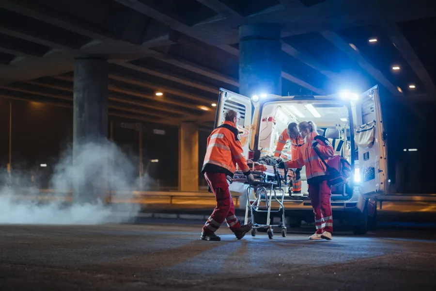 Ambulansepersonell bak en åpen ambulanse