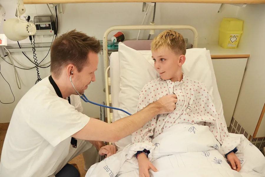 En mann i en sykehusseng med en ung gutt i en sykehusseng
