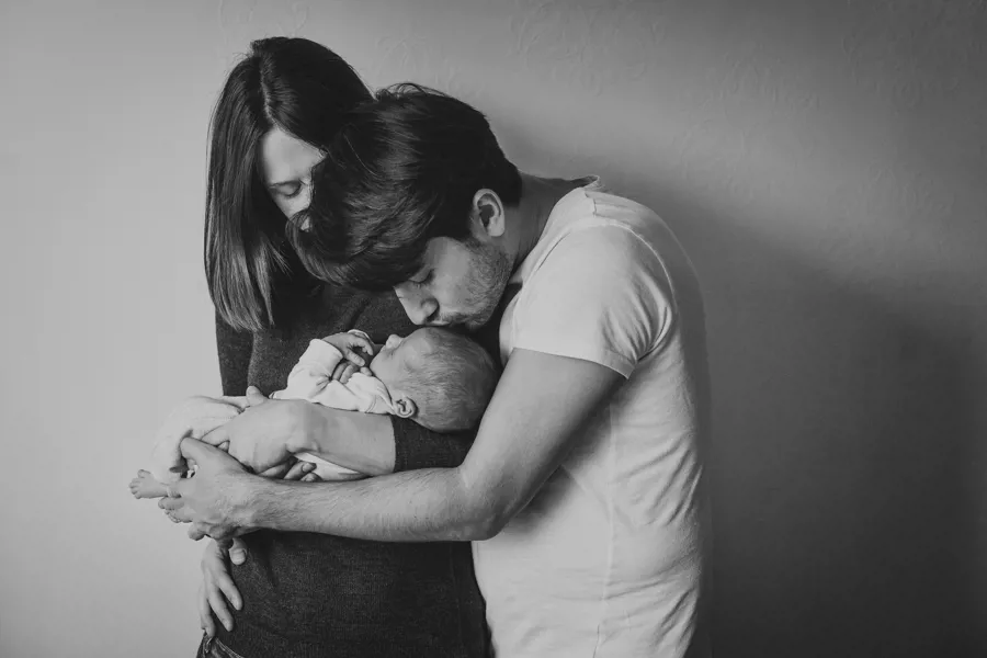To foreldre med sitt nyfødte barn i armene