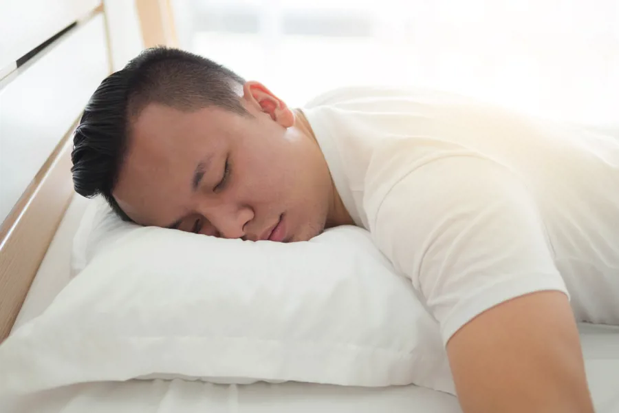 En person som sover på en seng