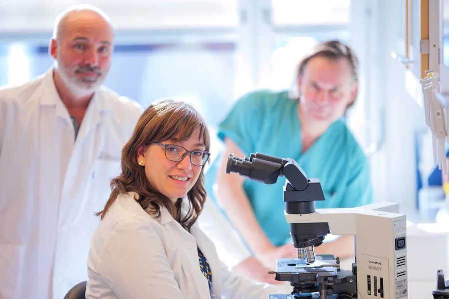 Bilde av leger som sitter ved et mkroskop