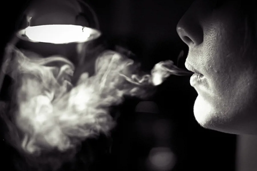 En person som blåser røyk
