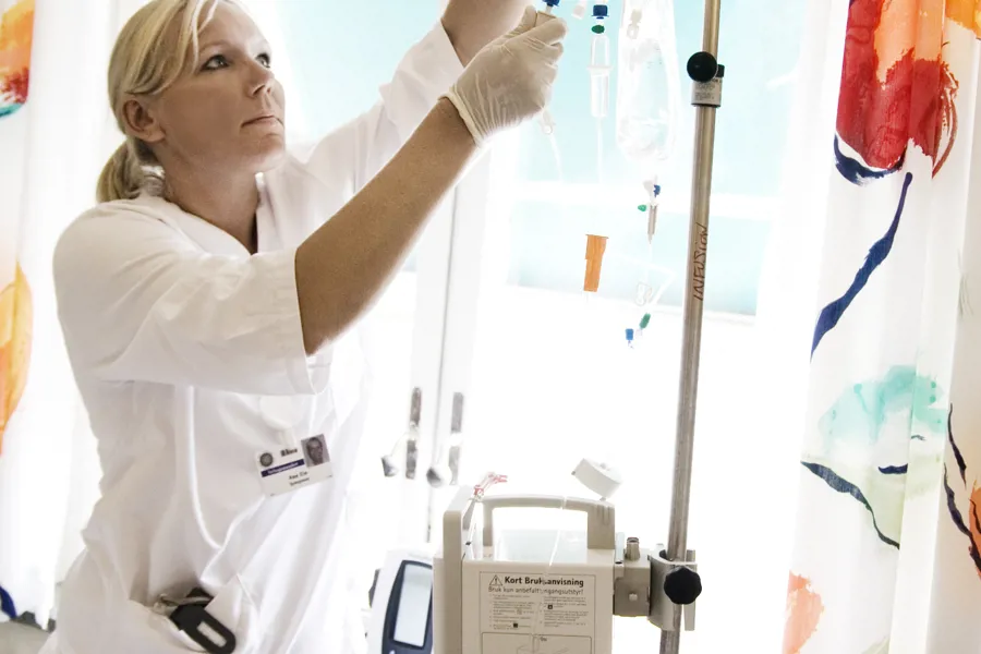 Foto av sykepleier som justerer cellegift på stativ