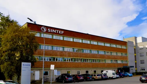 En bygning med biler parkert foran