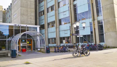 En gruppe sykler parkert utenfor en bygning