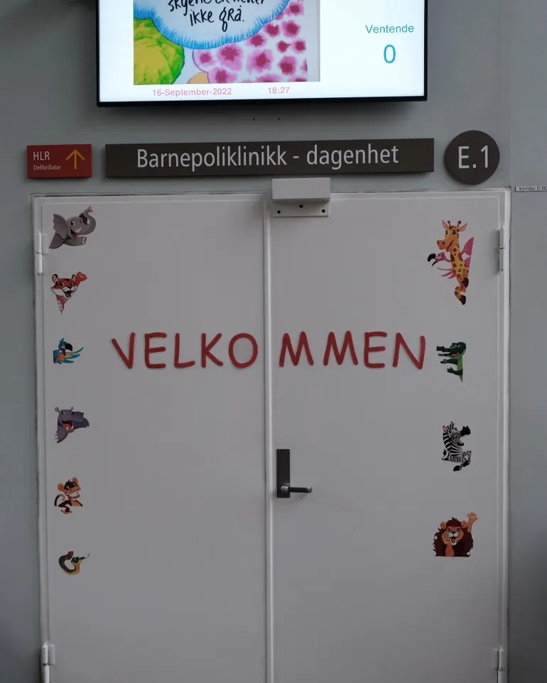 Inngangsdøren til barnepoliklinikken. På døren står det &quot;Velkommen&quot; med dyreklistremerker.