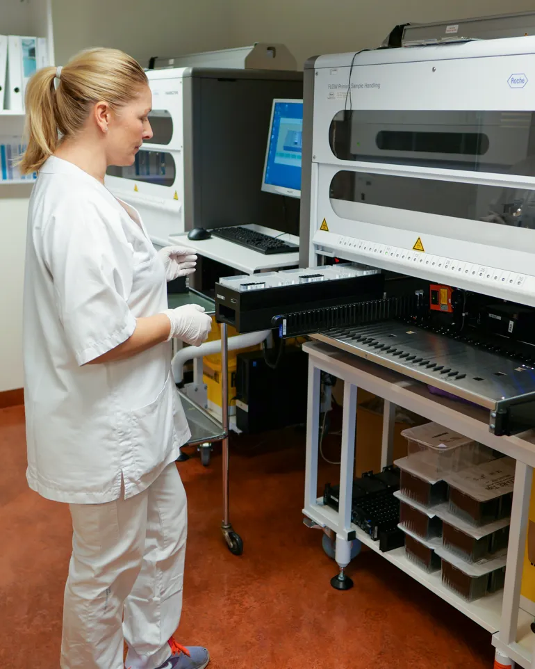 Foto:Bioingeniør som setter inn laboratorieprøver inn i labinstrument