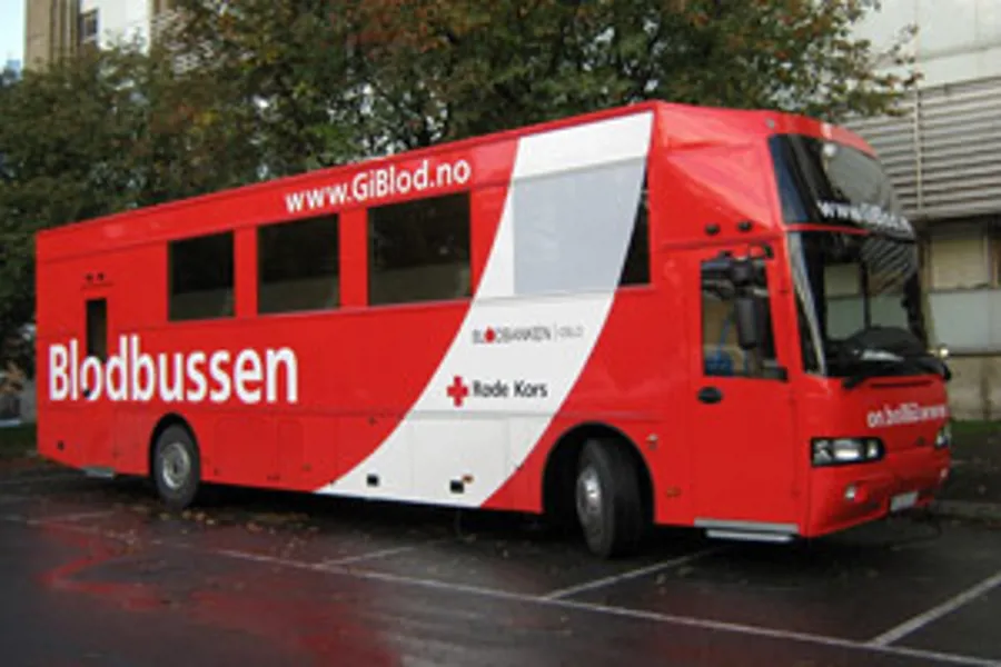 En rød buss parkert på en parkeringsplass