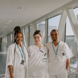 tre smilende bioingeniører i hvit uniform 