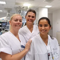 3 kvinnelige sykehusansatte i hvite uniformer
