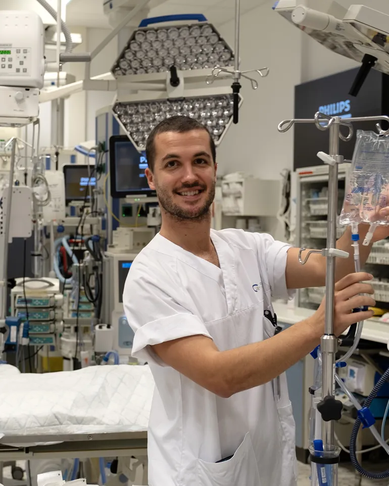 Mannlig sykepleier med infusjonsstativ