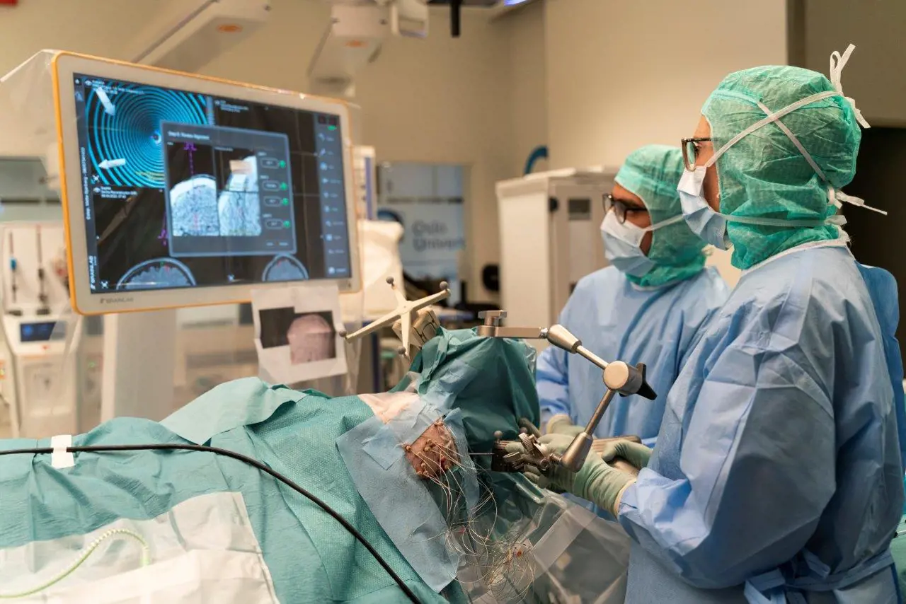 To kirurger ser på skjermen med CT-bilder under operasjonen