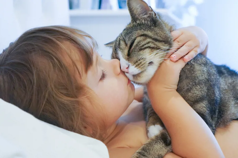 En jente som kysser en katt.