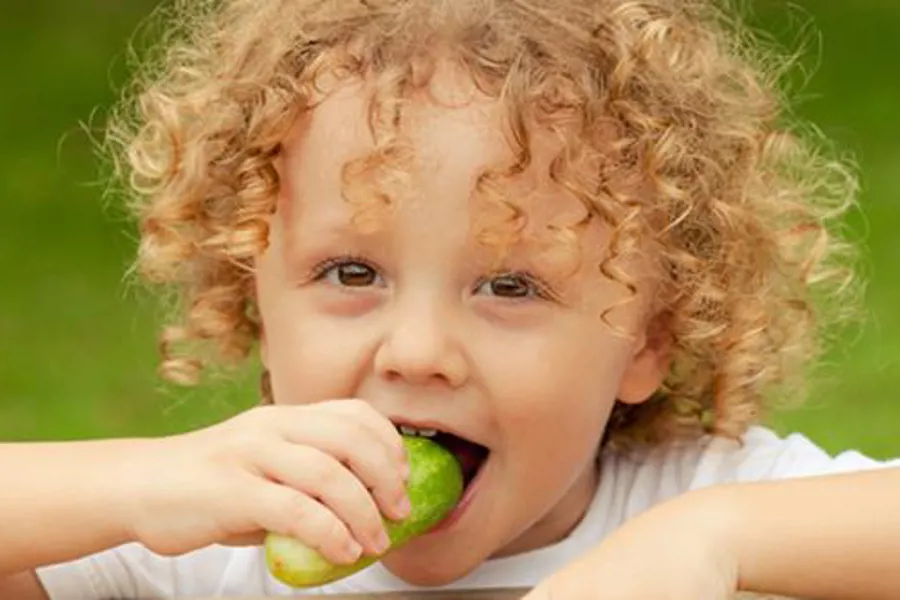 Gutt som spiser agurk.
