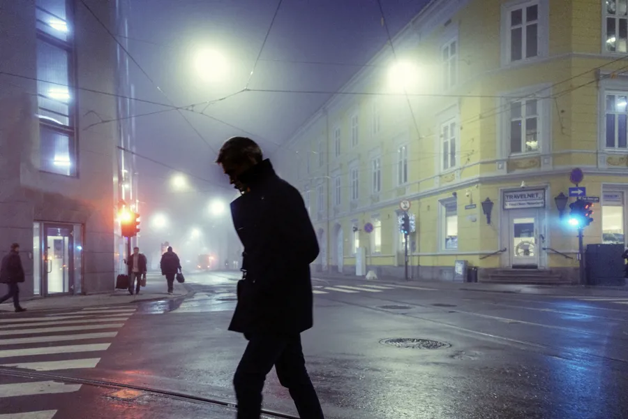 Fotografi av en mann som går alene i byen