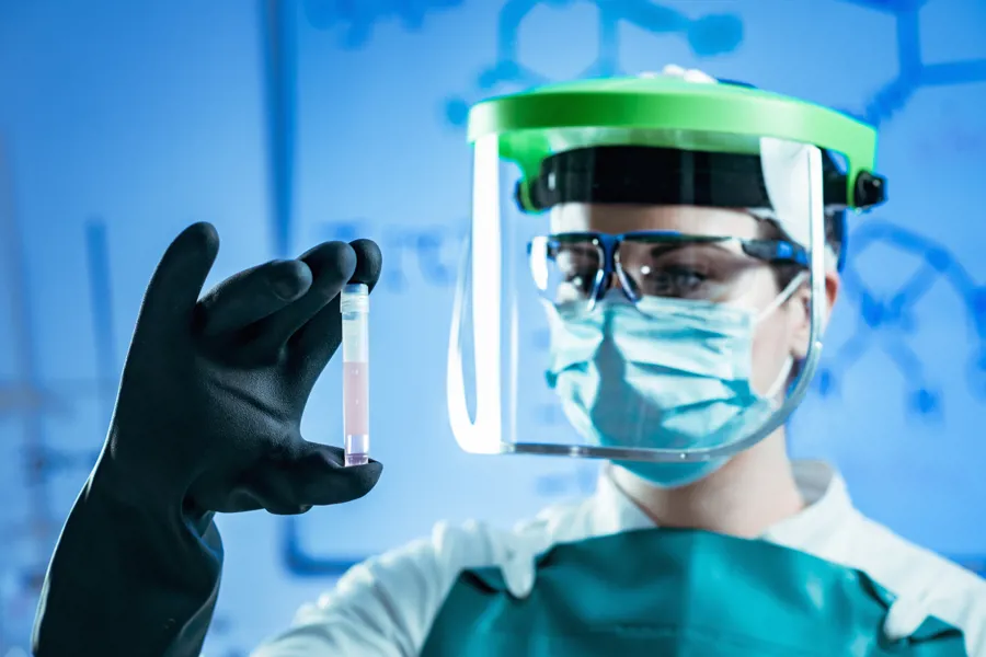 Laboratoriearbeider som holder et reagensglass