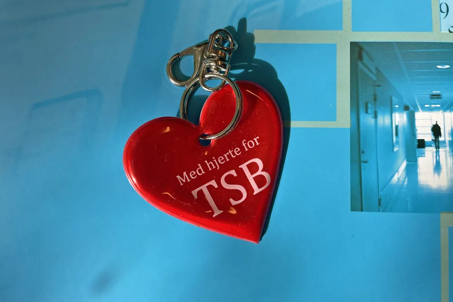 Bilde av en nøkkelring formet som et hjerte med teksten "Med hjerte for TSB"