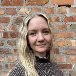 Woman in front of a brick wall