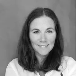 En kvinne som smiler til kameraet