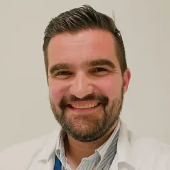 En mann med skjegg som smiler