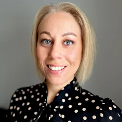 En kvinne som smiler til kameraet