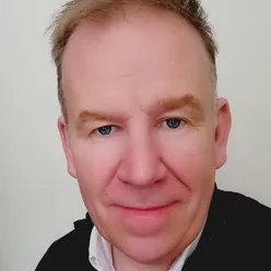 En mann som smiler til kameraet