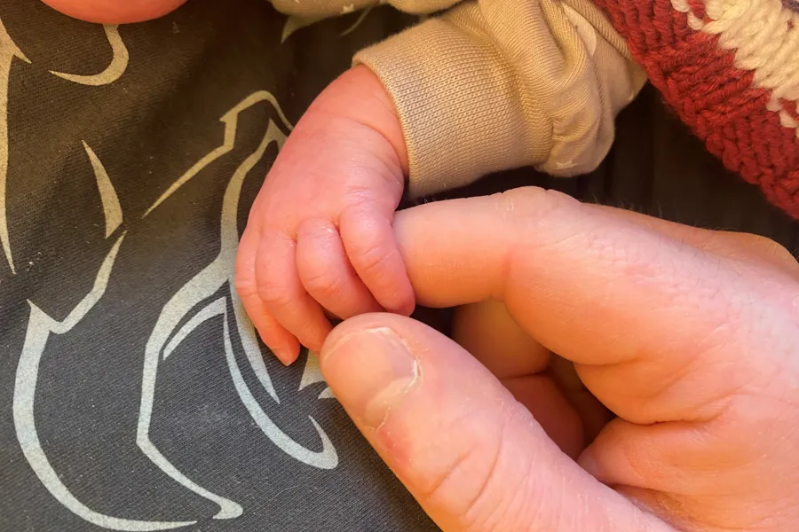 En person som holder en babys hånd