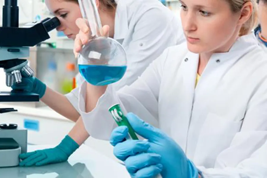 illustrasjonsfoto for å illustrere forskning. en kvinne ser i mikroskop, en i en kolbe og en med et prøveglass