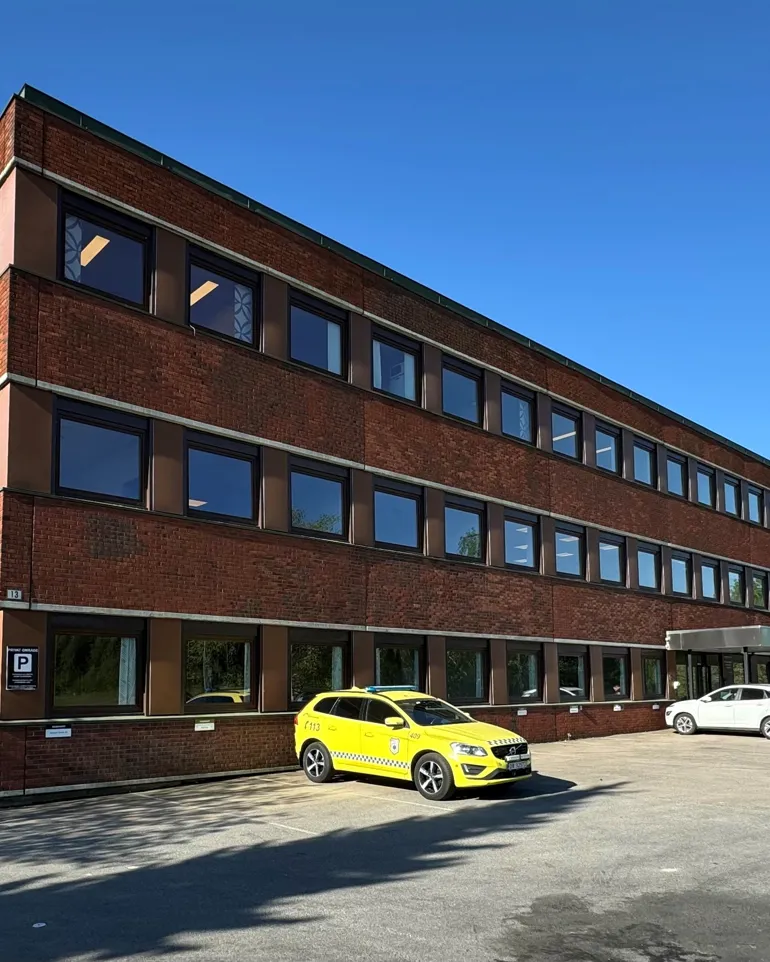 En bygning med biler parkert foran