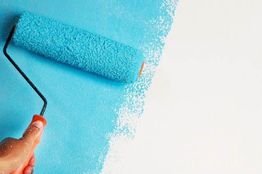 En person som maler et blått kunstverk