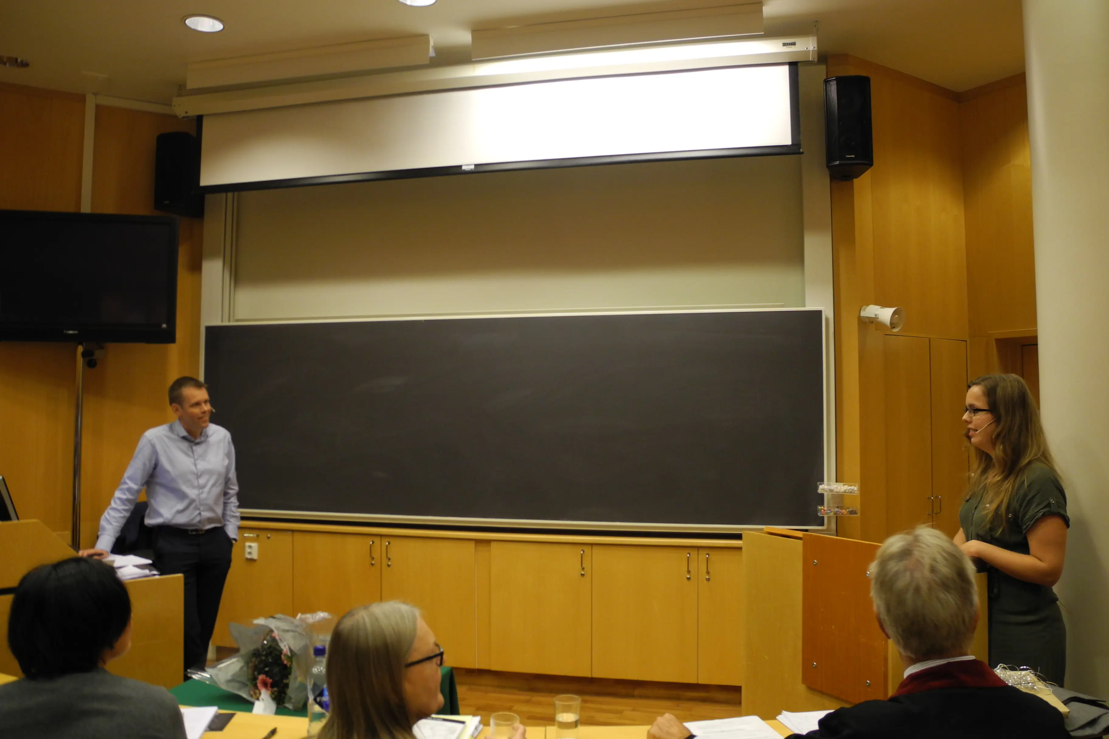 Her diskuterer Hilde T. Juvodden med andreopponent Harald Hrubos-Strøm foran en tavle.