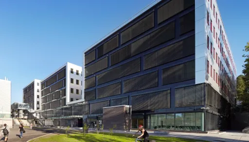 En stor bygning med en person som sykler