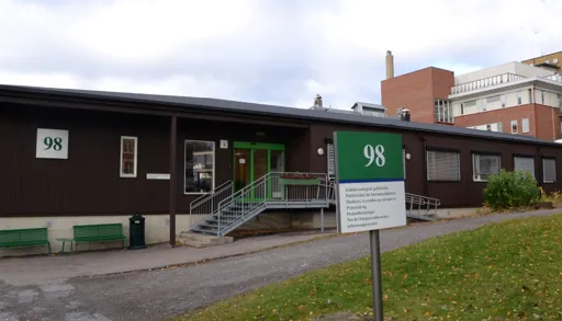 En bygning med benker og et skilt foran