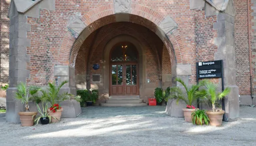 En murbygning med et skilt foran seg