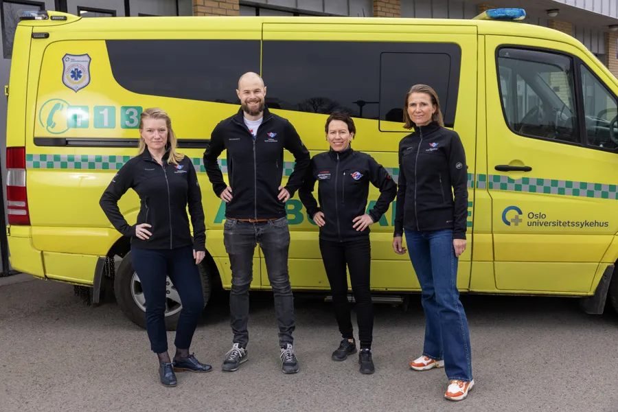 Bilde av forskerteamet foran en ambulanse.