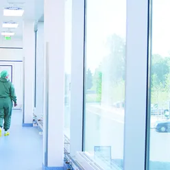 A health care worker walking down a hospital hallway.